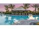 Community pool with lounge chairs, umbrellas, and palm trees in front of the Bahama Bar at 5646 Nevis Ter, Kissimmee, FL 34758