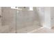 Glass-enclosed walk-in shower with beige tile walls at 5646 Nevis Ter, Kissimmee, FL 34758