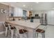 Well-lit kitchen featuring a tiled breakfast bar with seating, stainless steel appliances, and white cabinetry at 915 E Lake Parker Dr, Lakeland, FL 33801