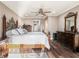 Main bedroom with hardwood floors, ceiling fan, dressers and a wrought iron bed frame at 915 E Lake Parker Dr, Lakeland, FL 33801