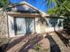 Exterior showing patio sliding door, stone accents, and windows at 1135 Linkside Ct, Apopka, FL 32712