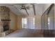 This living room boasts a stone fireplace, bright windows, and a ceiling fan at 1135 Linkside Ct, Apopka, FL 32712