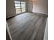 Bright bedroom featuring wood-look flooring, a white door, and a large window at 1460 Marvin C Zanders Ave, Apopka, FL 32703