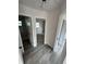 Bright hallway featuring gray wood-look flooring, white doors, leading to the bathroom, closet, and bedroom at 1460 Marvin C Zanders Ave, Apopka, FL 32703