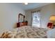 Cozy bedroom features floral bedding, wooden dresser, and natural light from the window at 9114 Cr 647A, Bushnell, FL 33513