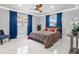 Comfortable bedroom with large windows, a modern ceiling fan, and stylish blue curtains at 226 Selkirk Way, Longwood, FL 32779