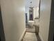 Hallway view of a modern bathroom with a standalone tub and decorative chandelier at 4513 Yorkshire Ln, Kissimmee, FL 34758