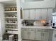 Bright kitchen featuring white cabinetry, open shelving pantry, and modern countertops at 4513 Yorkshire Ln, Kissimmee, FL 34758