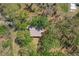 A bird's eye view of a roof showcases the home's place among lush, mature trees at 2920 Ewell Rd, Lakeland, FL 33811