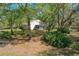 A backyard view shows the white home and a screened in porch among mature landscaping at 2920 Ewell Rd, Lakeland, FL 33811