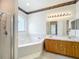 Bathroom featuring a garden tub, shower, and double sinks with marble counters at 2920 Ewell Rd, Lakeland, FL 33811