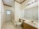 Bathroom featuring neutral tile, single sink vanity, toilet and shower/tub combo at 2920 Ewell Rd, Lakeland, FL 33811