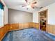 Open dining room with ceiling fan, wood paneled wainscoting, access to the kitchen and blue carpeting at 2920 Ewell Rd, Lakeland, FL 33811