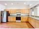 Spacious kitchen with wood cabinets, modern refrigerator, electric range, and laminate countertops at 2920 Ewell Rd, Lakeland, FL 33811