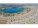 Expansive aerial view of a neighborhood surrounding a large lake with lush green landscaping at 928 Cambridge Dr, Winter Haven, FL 33881