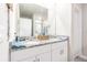 Bathroom featuring double sinks, granite countertops, white cabinets, and a large mirror at 928 Cambridge Dr, Winter Haven, FL 33881