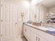 Bathroom featuring double sinks, granite countertops, white cabinets, and a large mirror at 928 Cambridge Dr, Winter Haven, FL 33881