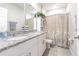 Bathroom featuring double sinks, granite countertops, white cabinets, and a decorative shower curtain at 928 Cambridge Dr, Winter Haven, FL 33881