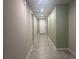 Well-lit hallway with neutral paint colors and tiled flooring at 928 Cambridge Dr, Winter Haven, FL 33881