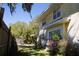 Charming home exterior with blooming bougainvillea flowers and mature trees at 114 1St Nw St, Fort Meade, FL 33841