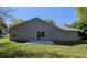 House backyard featuring a lush green lawn, a patio, and a modern exterior facade at 716 Byni Rdg, Winter Haven, FL 33880