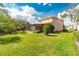 Expansive backyard featuring lush green grass, mature landscaping, and a screened-in lanai at 1229 Sebastian Cv, Lake Mary, FL 32746