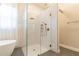 Bathroom with glass shower and tub, featuring neutral tile and gold accents at 1229 Sebastian Cv, Lake Mary, FL 32746