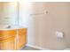 A partial view of a bathroom features a wood vanity with sink, mirror, towel bar, and toilet paper holder at 1229 Sebastian Cv, Lake Mary, FL 32746