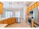 Bright kitchen featuring stainless steel appliances, wooden cabinets, and a large island with marble countertops at 1229 Sebastian Cv, Lake Mary, FL 32746