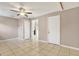 Neutral bedroom features a ceiling fan, tiled floors, and access to adjacent rooms at 2421 Cypress Ln, Lakeland, FL 33801