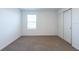 Bedroom with sliding door closet, neutral carpet, and window letting in natural light at 2506 Linda Knoll Ln, Bartow, FL 33830