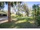 Spacious backyard includes lawns, a shed, other outbuildings, and an arbor, with trees draped in Spanish moss at 9415 Cat Track Trl, Lake Wales, FL 33898