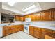 Traditional kitchen featuring wood cabinets, tile floors, and white appliances at 9415 Cat Track Trl, Lake Wales, FL 33898
