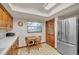 Cozy kitchen with a breakfast nook, stainless steel refrigerator, and wood cabinets at 9415 Cat Track Trl, Lake Wales, FL 33898
