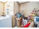 Compact laundry room with a washer, dryer, hot water heater, and additional storage space at 9415 Cat Track Trl, Lake Wales, FL 33898