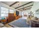 Cozy living room with tile floors, a beamed ceiling, and a view into the dining area at 9415 Cat Track Trl, Lake Wales, FL 33898
