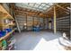 Interior of large metal outbuilding is ready for projects with shelves, work space, and tall overhead clearance at 9415 Cat Track Trl, Lake Wales, FL 33898