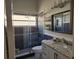 Updated bathroom featuring a modern shower with sleek tile, glass doors and granite vanity at 2691 Cedaridge Cir, Clermont, FL 34711