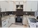 Beautiful kitchen showcasing white cabinets, stainless steel appliances and stylish backsplash at 2691 Cedaridge Cir, Clermont, FL 34711