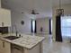 Contemporary kitchen area view, seamless to living room, including granite counters and stainless appliances at 2691 Cedaridge Cir, Clermont, FL 34711