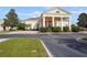 Stately clubhouse featuring a grand entrance with prominent white columns, a red brick drive, and beautiful landscaping at 5103 Bridgehaven Rd, Davenport, FL 33837