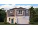 Charming two-story home with gray siding, a two-car garage, a teal front door, and lush surrounding landscaping at 5103 Bridgehaven Rd, Davenport, FL 33837