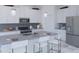 Bright kitchen featuring white cabinets, stainless steel appliances, an island with seating, and modern pendant lighting at 5103 Bridgehaven Rd, Davenport, FL 33837
