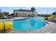 A community pool with a waterslide and lounge chairs, surrounded by lush landscaping on a sunny day at 5103 Bridgehaven Rd, Davenport, FL 33837