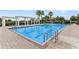 A large community swimming pool with lounge seating and a pergola, perfect for relaxing in the sun at 5103 Bridgehaven Rd, Davenport, FL 33837