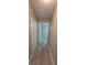 Clean hallway with light wood floors and white closet doors, leading to a room with lots of natural light at 6372 Raleigh St # 1911, Orlando, FL 32835