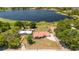 Aerial shot of a lakeside home with a red roof, set on a spacious lot with mature trees and water views at 5020 Old Lucerne Park Rd, Winter Haven, FL 33881