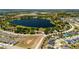 Expansive aerial view of a residential area featuring a lake and a home with a red roof amid lush surroundings at 5020 Old Lucerne Park Rd, Winter Haven, FL 33881