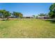 Lush green backyard with a view of the home's exterior and a glimpse of the surrounding neighborhood at 5020 Old Lucerne Park Rd, Winter Haven, FL 33881