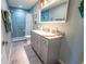Beautiful bathroom with a walk-in shower with blue tile, granite vanity, and modern fixtures at 5020 Old Lucerne Park Rd, Winter Haven, FL 33881